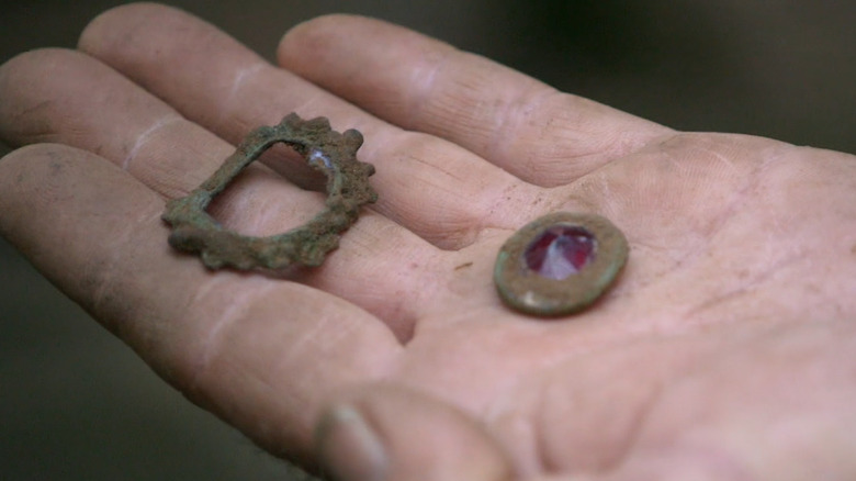 Hand holds pieces of brooch