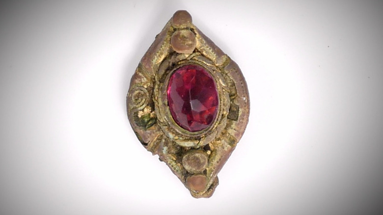 Gold brooch encircles red jewel