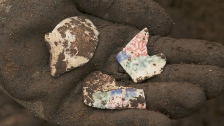 Hand holding painted pottery