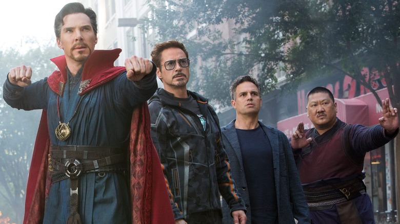 Doctor Strange, Tony Stark, Bruce Banner and Wong standing outdoors while facing an unseen threat