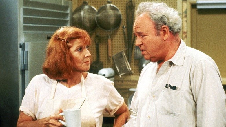 Veronica stands near Archie Bunker