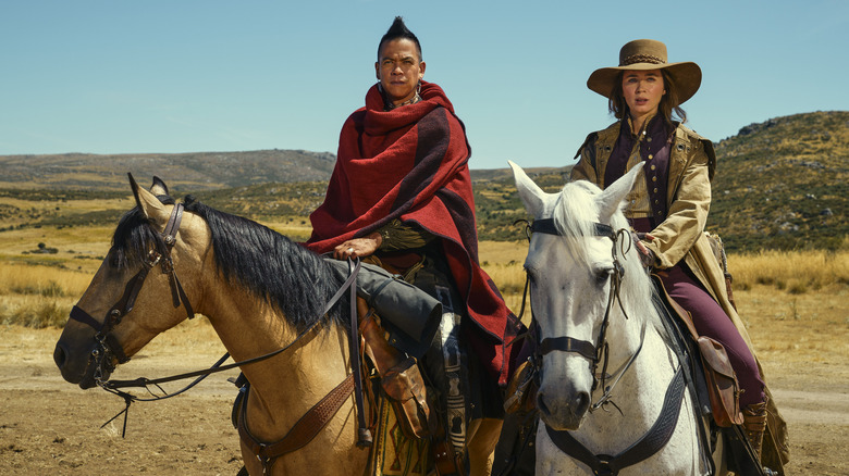 Chaske Spencer and Emily Blunt sitting on horses together