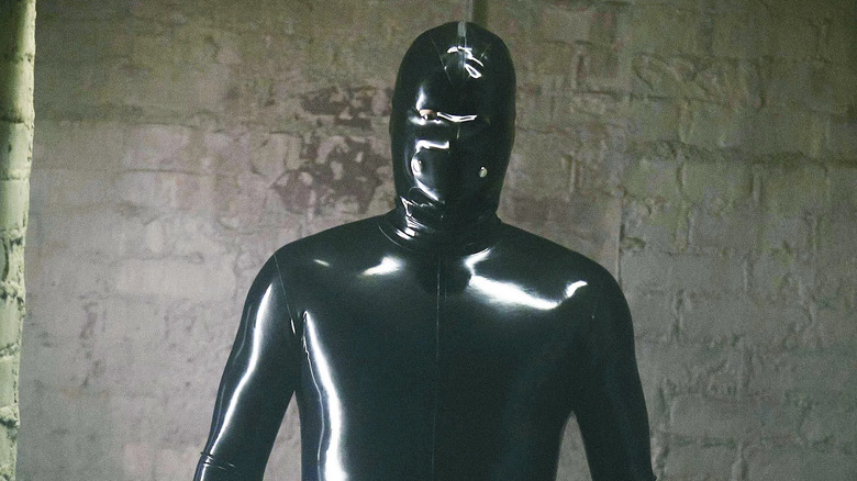 Rubber Man standing and staring