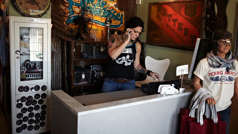 Danielle on the phone behind the counter of an antiques store