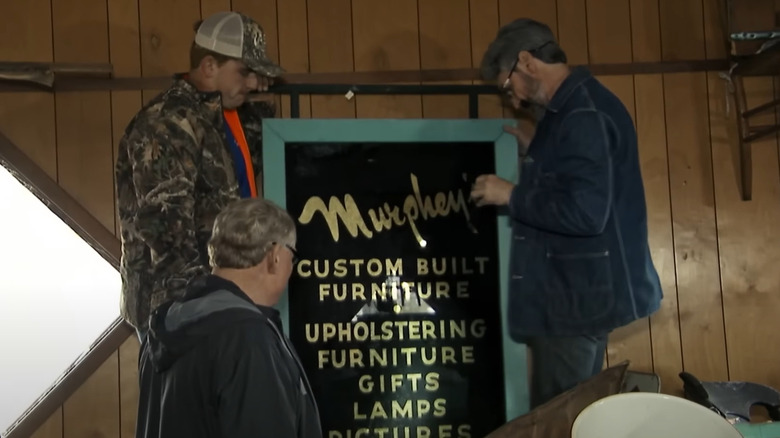 Mike Wolfe and another man inspecting a sign