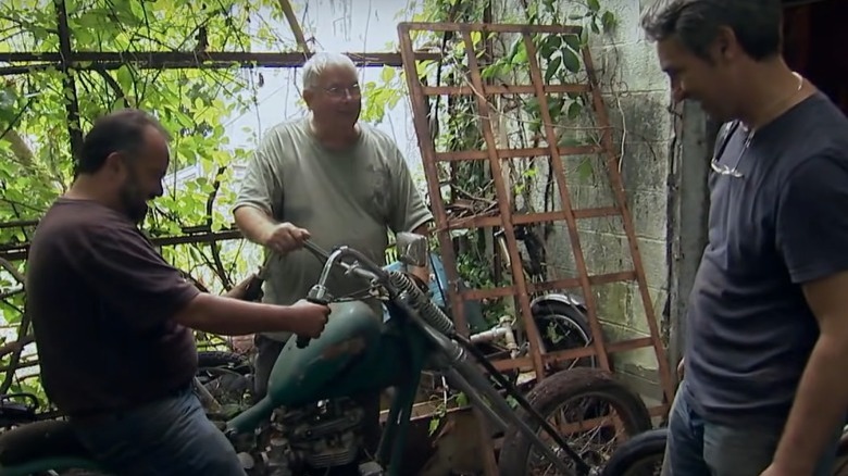 Frank Fritz and Mike Wolfe looking at a motorcycle