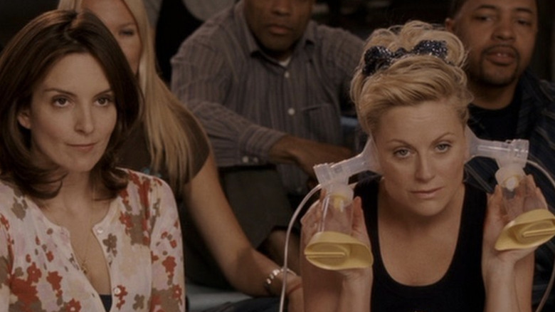 Tina Fey sits next to Amy Poehler with breast pumps to her ears