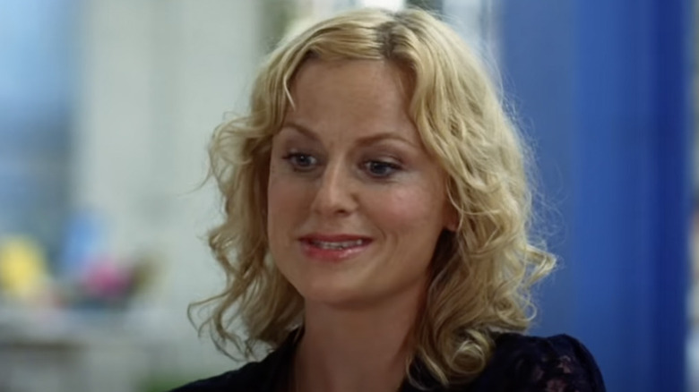 Amy Poehler looks down with half smile