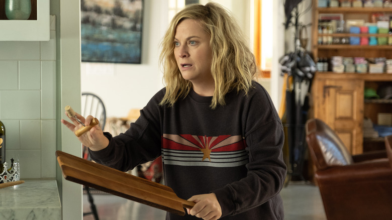 Amy Poehler holds corkscrew and cheeseboard like weapons