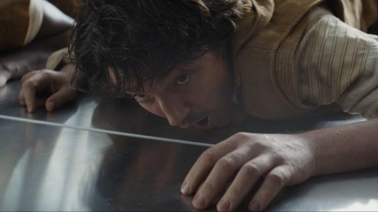 Cassian Andor gasps in pain on a tunqstoid steel floor