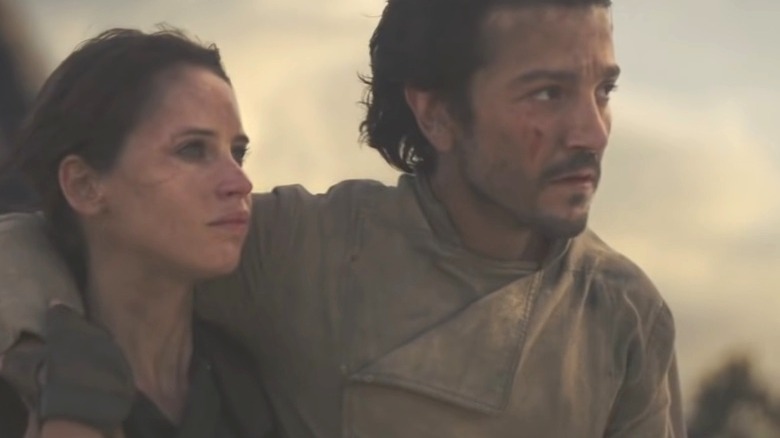 Cassian Andor and Jyn Erso sit on the beach waiting to die on Scarif.