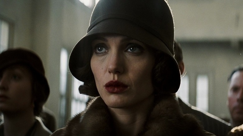 Angelina Jolie somberly looks up in 1920s setting