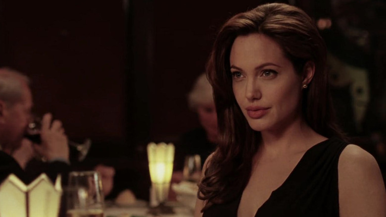 Angelina Jolie looks up at table with small smile