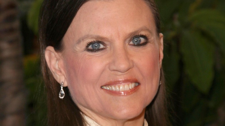 Ann Reinking smiling at event with green background