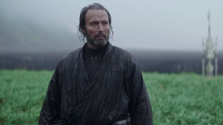 Galen Erso standing in grass field