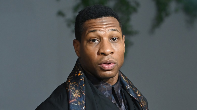 Jonathan Majors wearing a colorful scarf