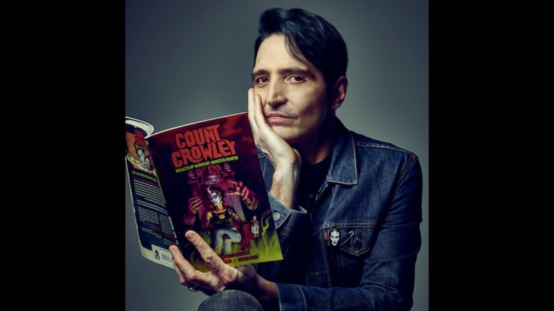 David Dastmalchian posing with a Count Crowley comic book