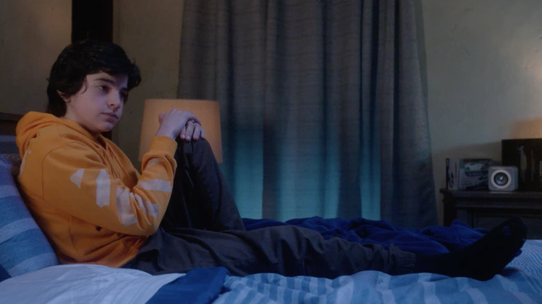 Griffin Santopietro sits on bed in Cobra Kai