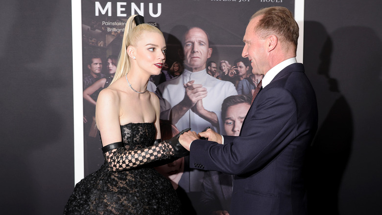 Anya Taylor-Joy and Ralph Fiennes greet each other at event