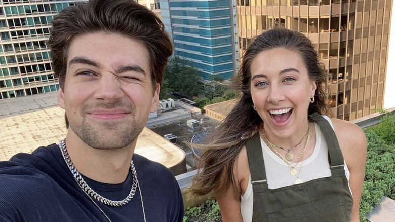 Zac taking a selfie with his sister on a rooftop garden