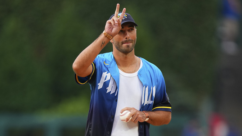 Joey Graziadei flashes a peace sign with a baseball in his hand