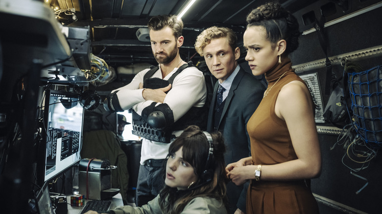 Stuart Martin, Ruby O. Fee, Matthias Schweighöfer and Nathalie Emmanuel gathered around monitors in "Army of Thieves"