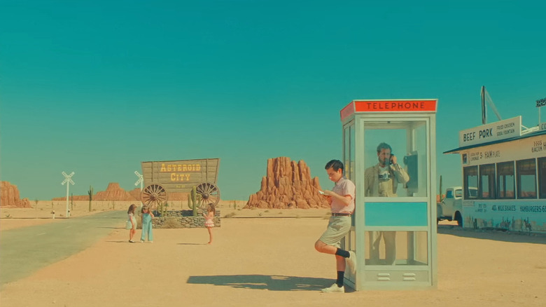 Augie and his children wait near a phone booth