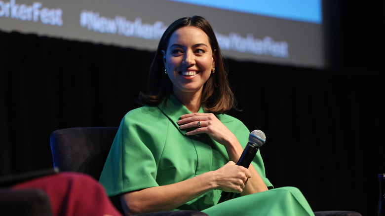 Aubrey Plaza speaks onstage in a green outfit