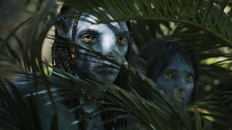 Neteyam and Kiri peaking through vegetation