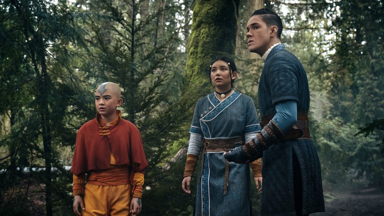 Aang, Katara, and Sokka standing in forest 