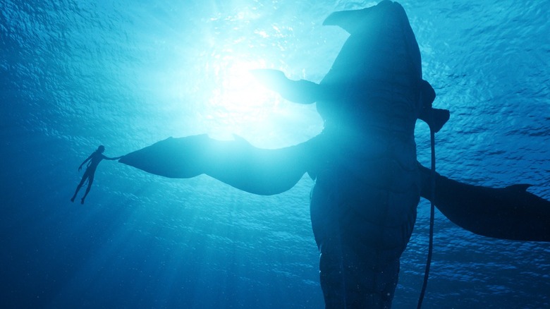 A Na'vi swimming with a tulkun