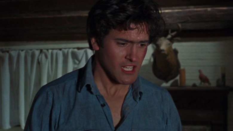 Ash in denim shirt looking frightened in The Evil Dead (1981)