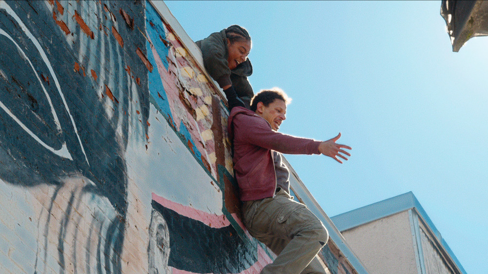 Eric Andre being dangled off of a ledge