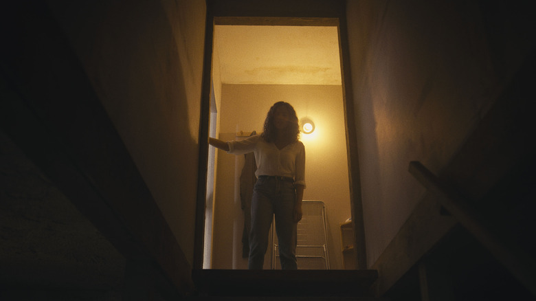 Tess looking down into the basement