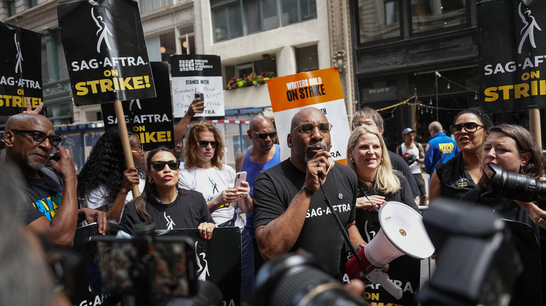 Alexandra Ocasio Cortez and Ezra Knight stand with SAG-AFTRA picket line