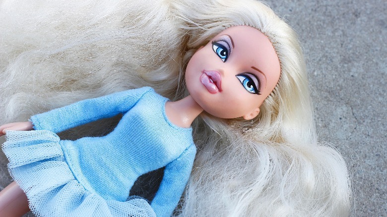 Bratz doll in blue dress lying on ground