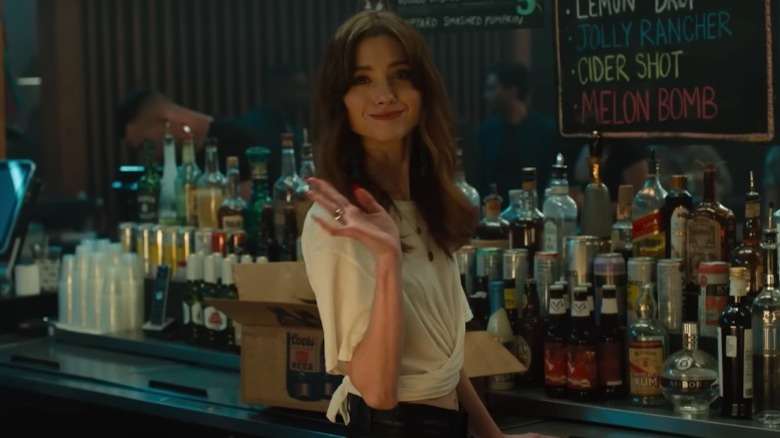 Chloe waving while working at the bar 