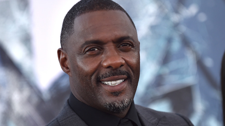 Idris Elba looking up and smiling