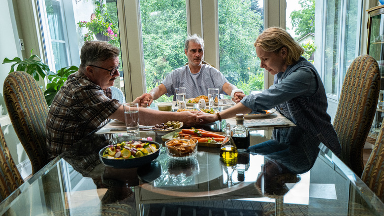 Grace, Roger, and Beau saying grace at dinner