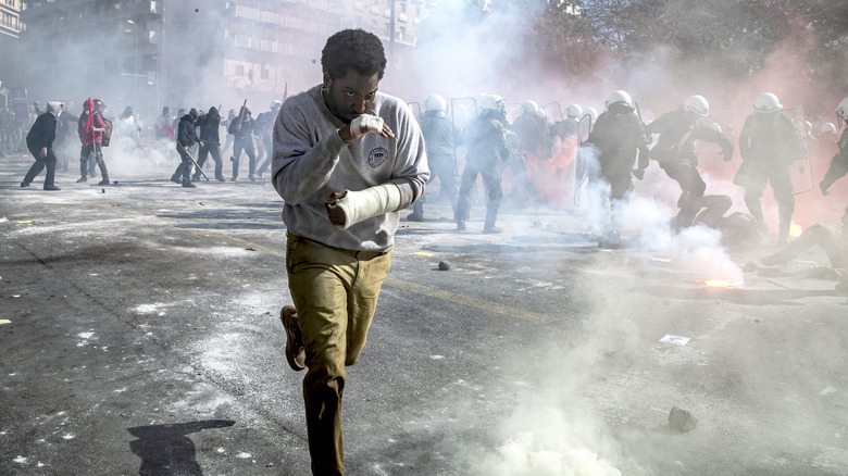 Beckett running through protest smoke