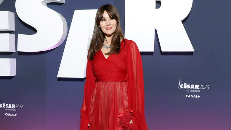 Monica Bellucci smiling and wearing red dress at red carpet