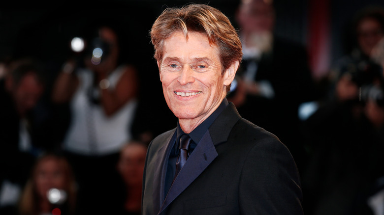 Willem Dafoe smiling for camera