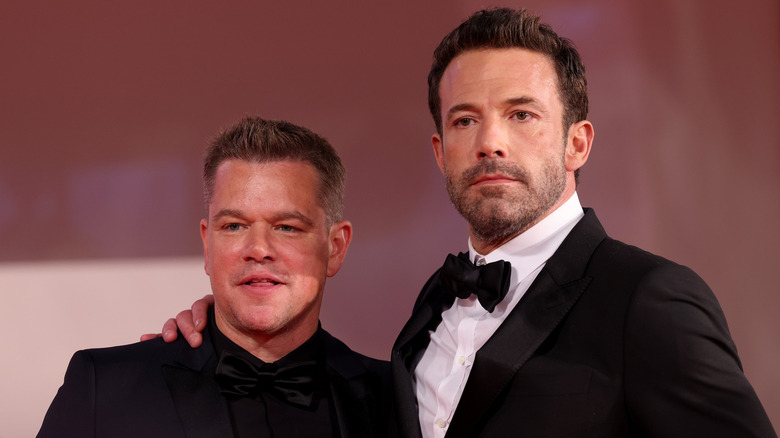 Ben Affleck and Matt Damon wearing suits posing for the camera