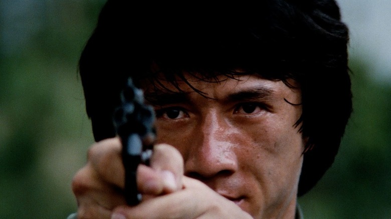 Jackie Chan aims gun