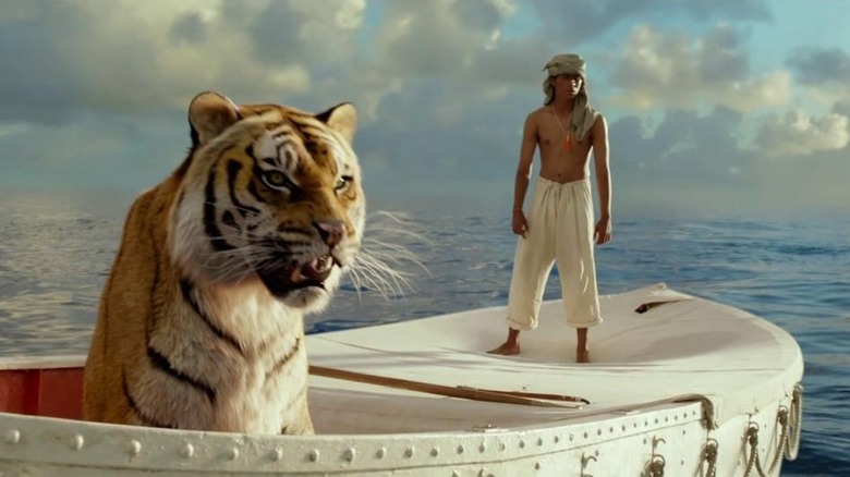 Pi standing on boat with a tiger