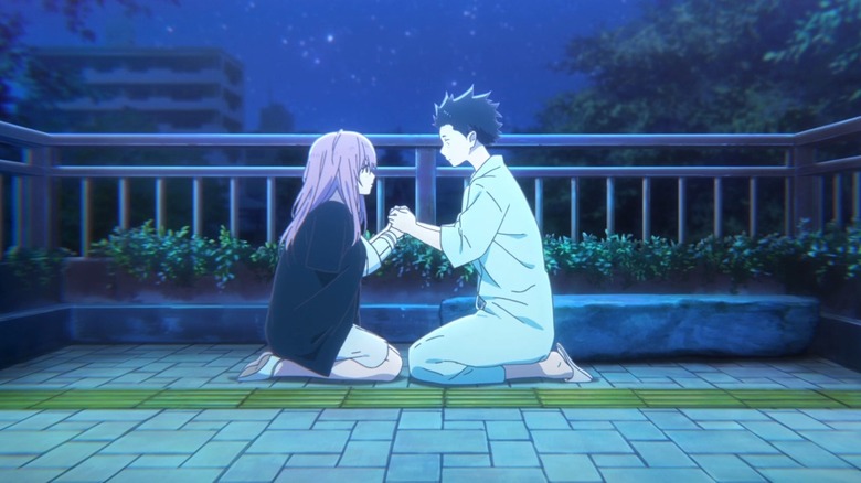 Shoko and Shoya holding hands at night on a bridge