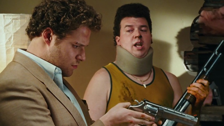 Seth Rogen carrying a gun