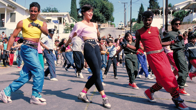 Three breakdancers perform in the street