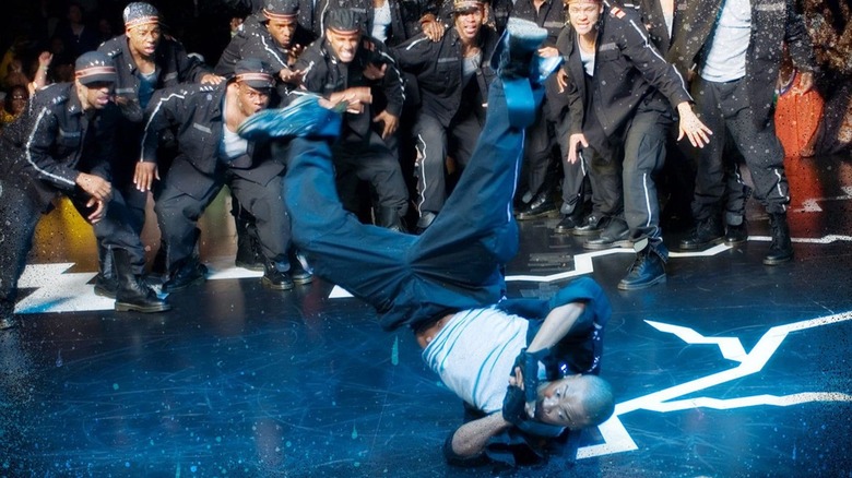 One man hits the floor mid-breakdance while a crowd watches