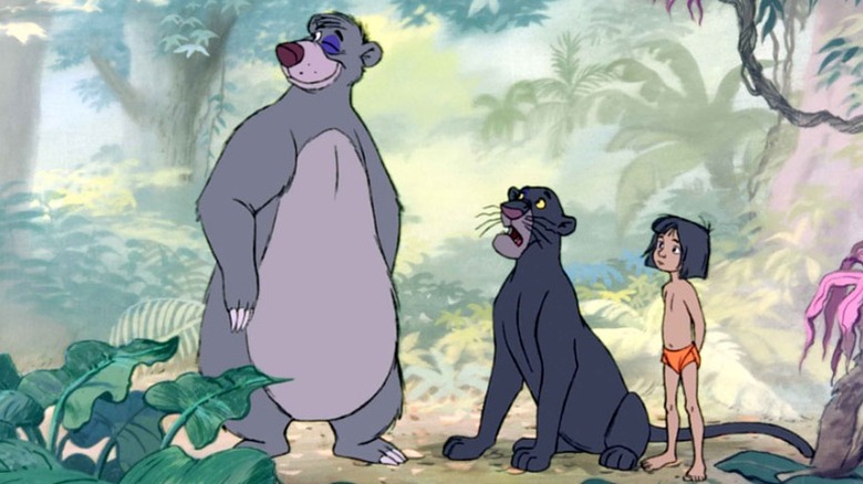 Mowgli, Baloo, and Bagheera standing together in the jungle